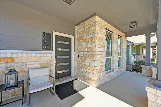 view of exterior entry featuring covered porch