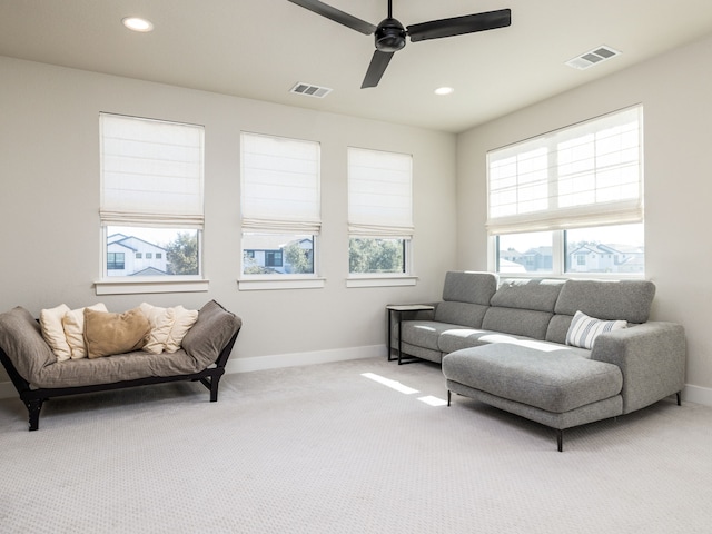 carpeted living room with ceiling fan