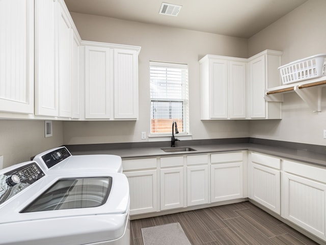 clothes washing area featuring sink, cabinets, and washing machine and clothes dryer