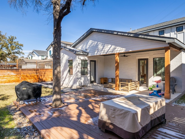 rear view of house featuring ceiling fan and a deck