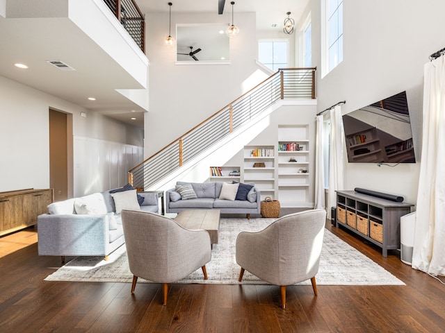 living room featuring hardwood / wood-style flooring, a high ceiling, and built in shelves