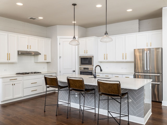 kitchen with white cabinets, stainless steel appliances, and pendant lighting