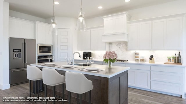 1716 Snowdrop Dr, Georgetown, TX 78628 - kitchen with stainless steel appliances, wood finished floors, a center island with sink, white cabinetry, and recessed lighting