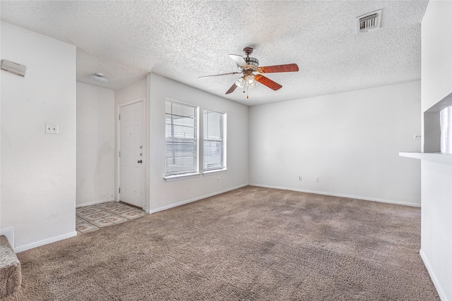 carpeted spare room with ceiling fan and a textured ceiling