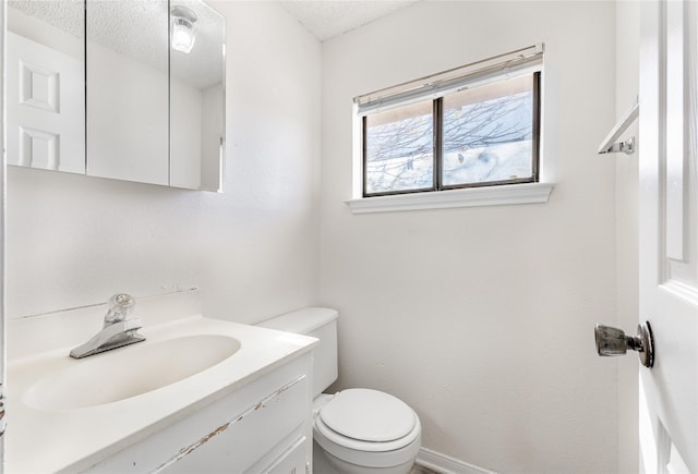 bathroom featuring a textured ceiling, toilet, and vanity