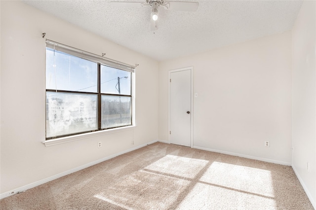 carpeted empty room featuring ceiling fan and a textured ceiling