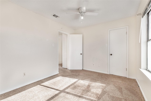 unfurnished bedroom with ceiling fan and light colored carpet