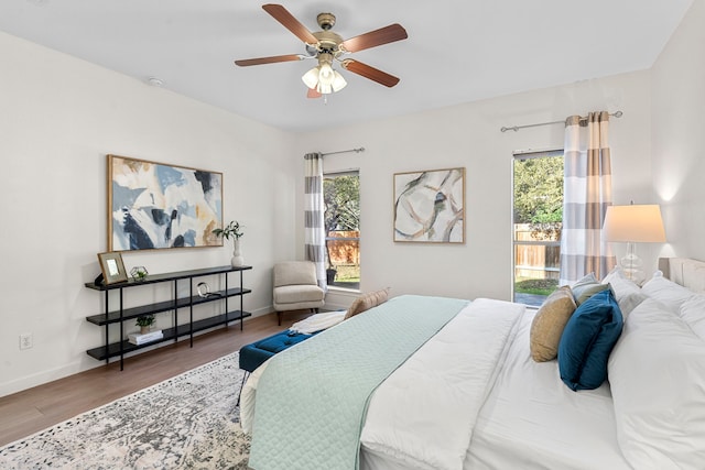 bedroom featuring multiple windows, wood-type flooring, and ceiling fan