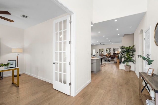 hall featuring light hardwood / wood-style flooring and french doors