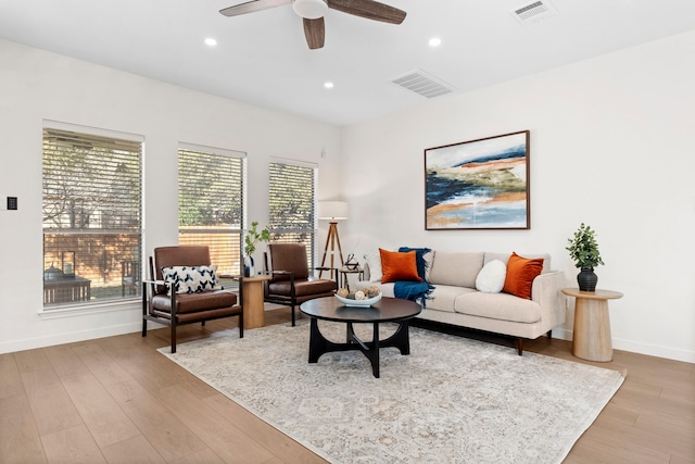 living room featuring a wealth of natural light, ceiling fan, and light hardwood / wood-style flooring