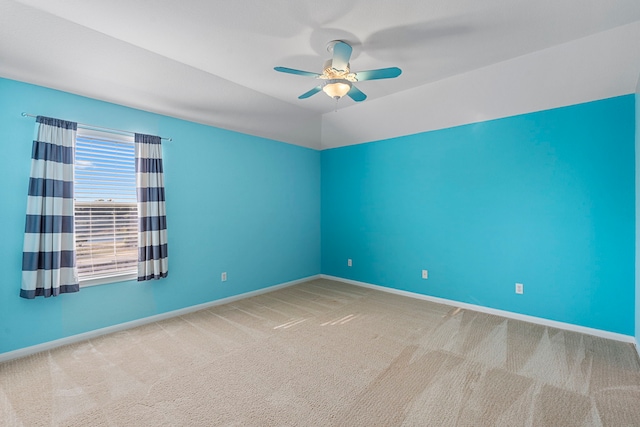 spare room featuring vaulted ceiling, carpet, and ceiling fan