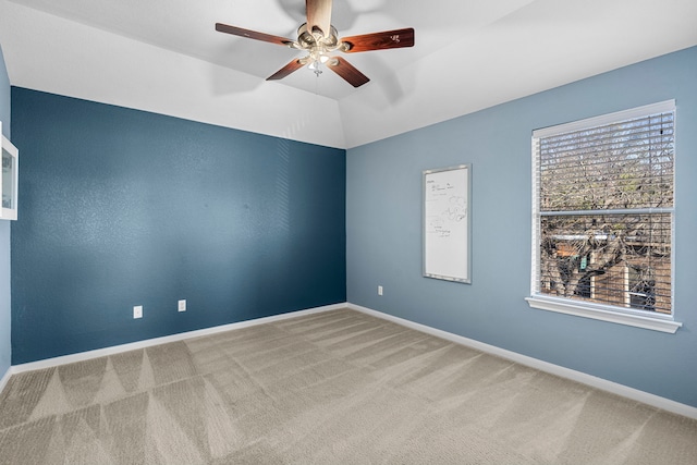 carpeted spare room with vaulted ceiling and ceiling fan