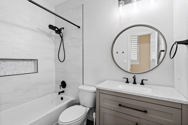 full bathroom with vanity, tiled shower / bath combo, and toilet