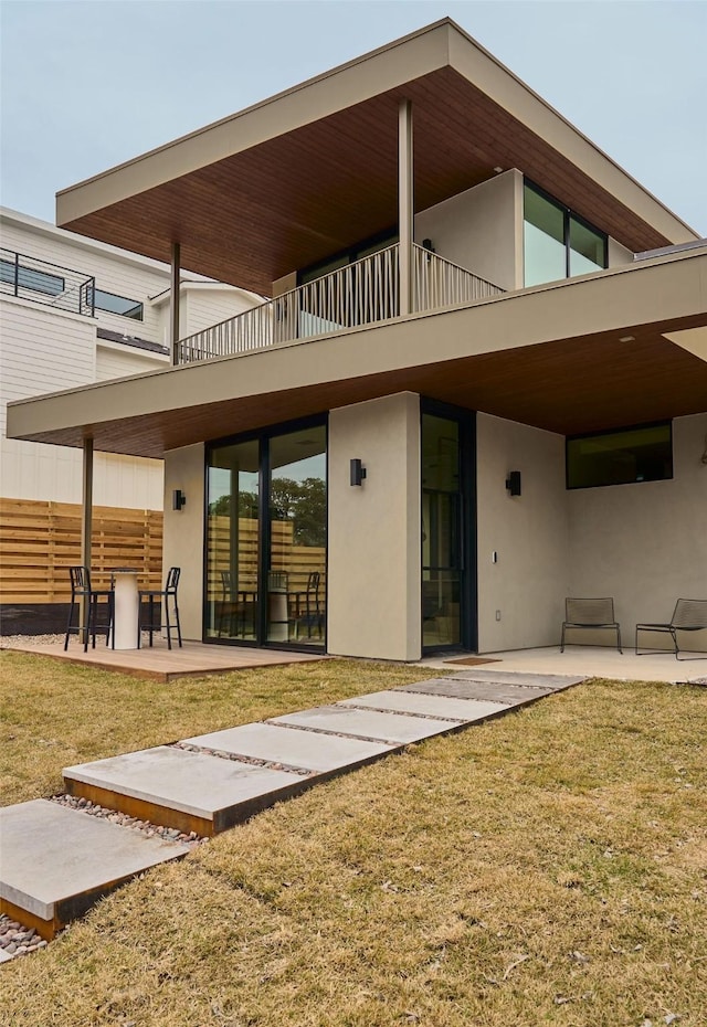 back of property featuring a patio area and a lawn