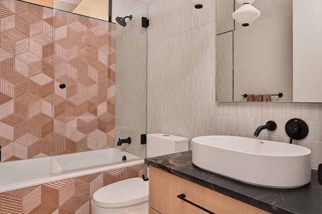 full bathroom featuring toilet, tiled shower / bath combo, tile walls, vanity, and backsplash