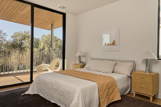 bedroom featuring a wall of windows and access to outside