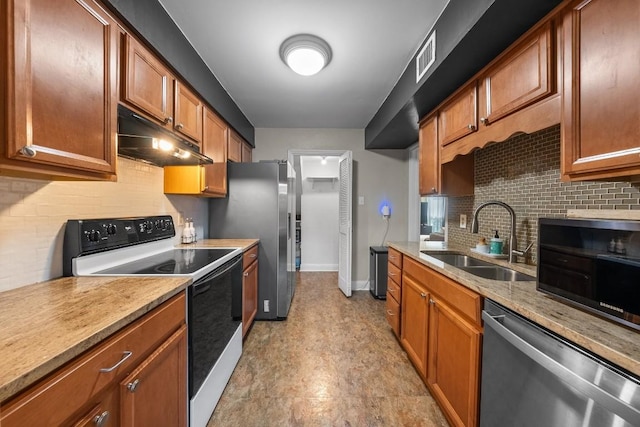 9009 N Plz Unit 118, Austin, TX 78753 - kitchen with stainless steel appliances, a sink, under cabinet range hood, tasteful backsplash, and baseboards