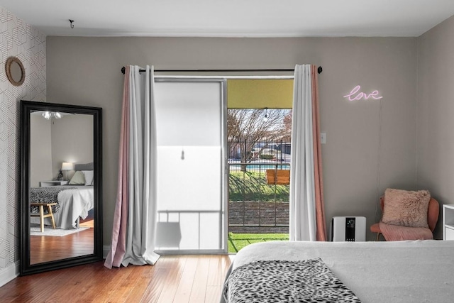 9009 N Plz Unit 118, Austin, TX 78753 - bedroom with multiple windows, wood finished floors, and access to exterior