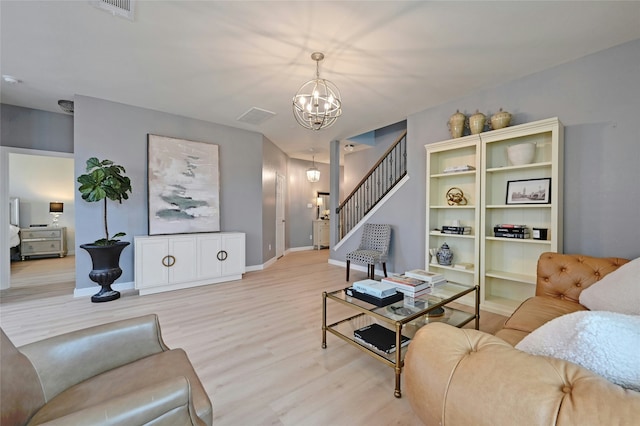 living room with a notable chandelier and light hardwood / wood-style flooring