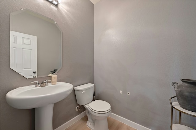 bathroom featuring hardwood / wood-style flooring and toilet