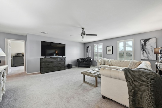 carpeted living room with ceiling fan