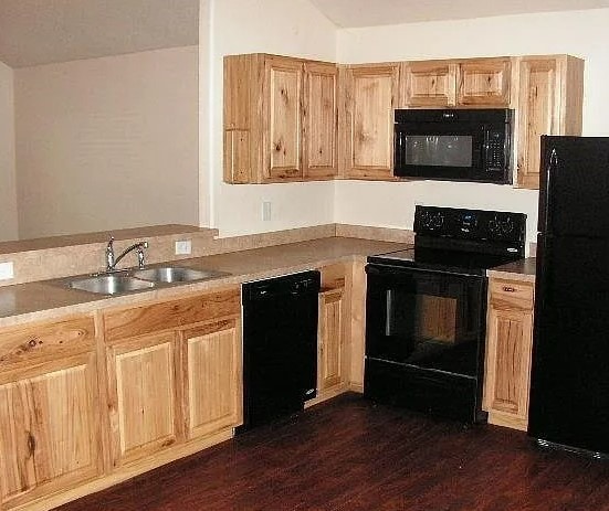 kitchen featuring black appliances, light brown cabinets, dark hardwood / wood-style floors, and sink