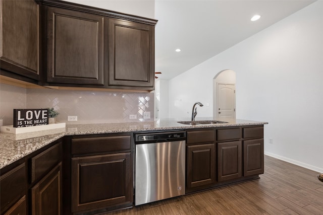 kitchen with dark hardwood / wood-style flooring, light stone countertops, dark brown cabinets, and stainless steel dishwasher