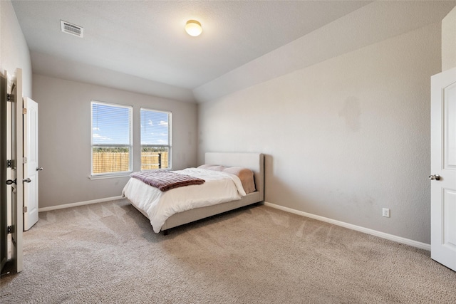 carpeted bedroom with vaulted ceiling