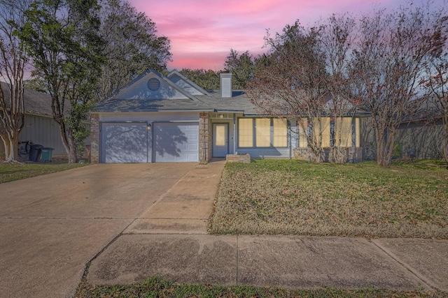 view of front of house featuring a garage and a lawn