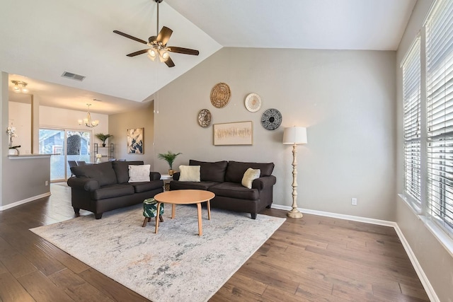 living room featuring ceiling fan with notable chandelier, dark wood-type flooring, and high vaulted ceiling