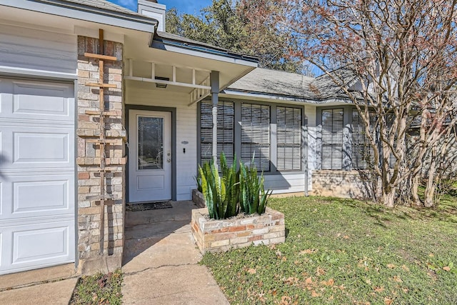 view of exterior entry with a yard