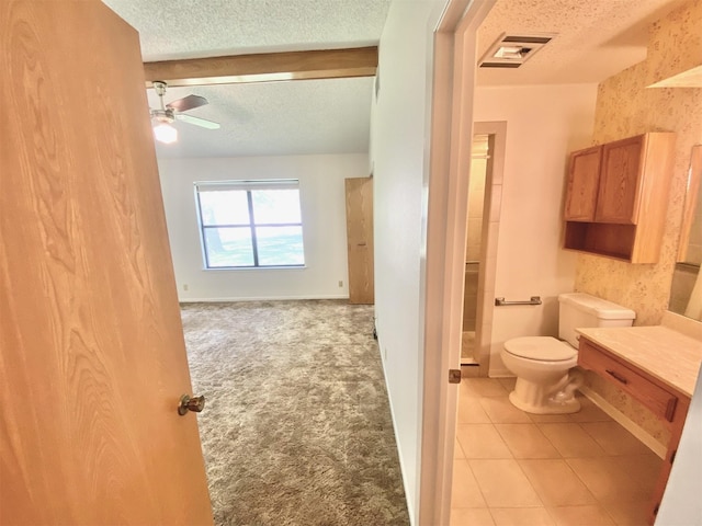 bathroom with ceiling fan, a textured ceiling, toilet, and vanity