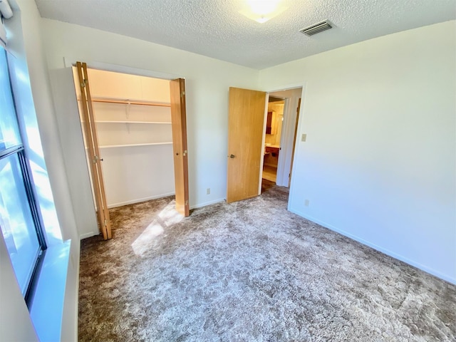 unfurnished bedroom with a closet, a textured ceiling, and carpet floors