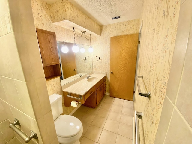 bathroom featuring toilet, a textured ceiling, tile patterned flooring, and vanity