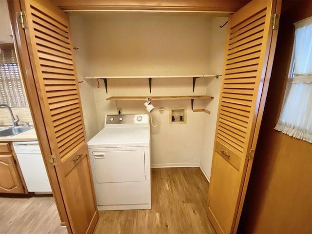 washroom with sink, light hardwood / wood-style flooring, and washer / dryer