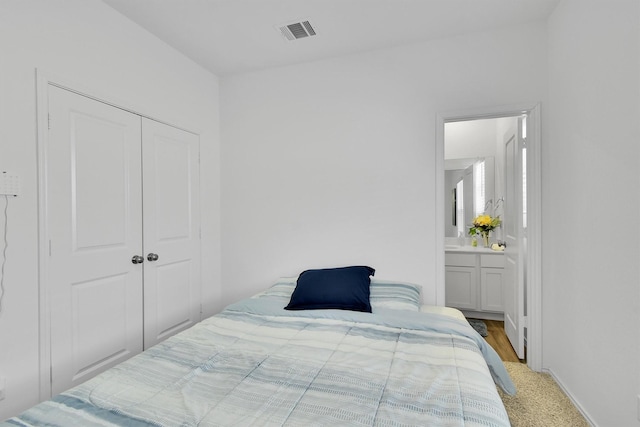 bedroom featuring connected bathroom, carpet, and a closet