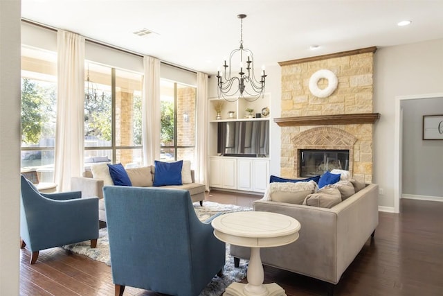 living area with a fireplace, visible vents, baseboards, dark wood finished floors, and an inviting chandelier