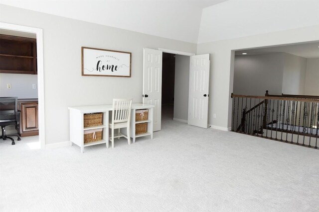 carpeted office space featuring lofted ceiling