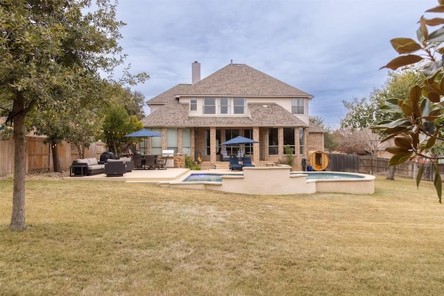 rear view of property featuring a fenced in pool, a lawn, a patio, and an outdoor living space with a fireplace