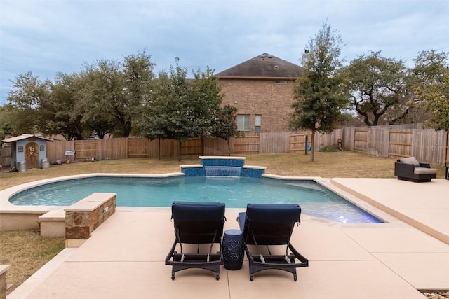 view of swimming pool featuring a storage shed, a patio area, and pool water feature