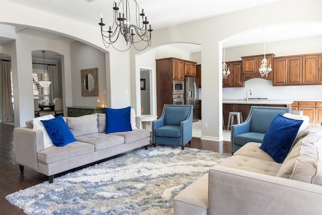 living room with dark hardwood / wood-style flooring, sink, and a notable chandelier