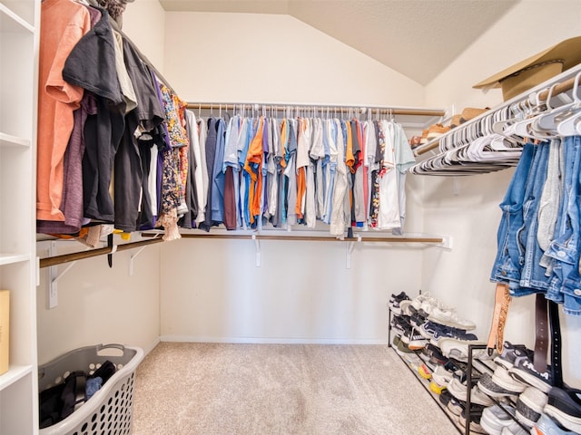 walk in closet featuring vaulted ceiling and carpet