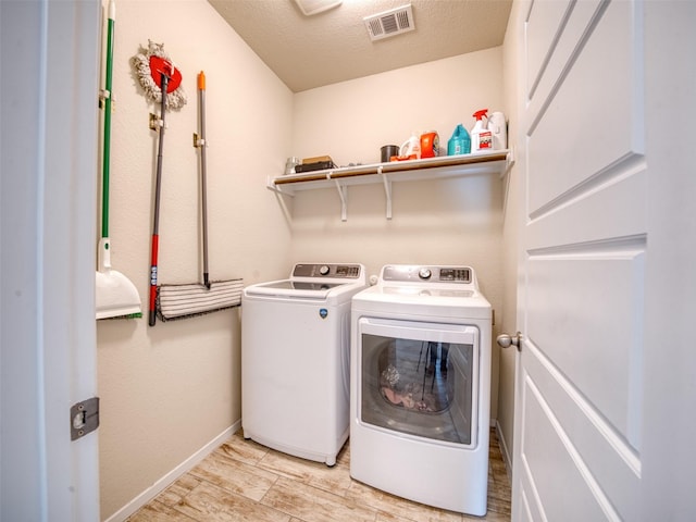 laundry area featuring a textured ceiling and washer and dryer