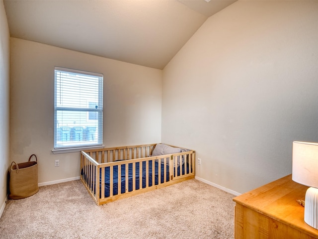 bedroom with a nursery area, carpet flooring, and lofted ceiling