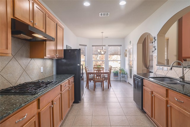 kitchen with pendant lighting, sink, backsplash, dark stone counters, and black appliances