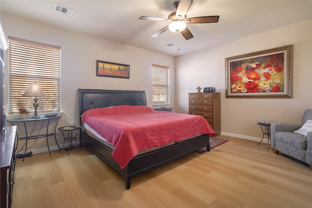 bedroom with ceiling fan, light hardwood / wood-style flooring, and multiple windows