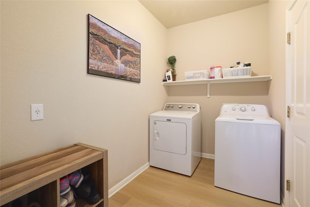 clothes washing area with light hardwood / wood-style floors and washing machine and clothes dryer