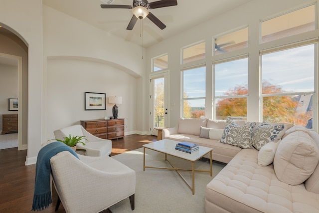 living room featuring ceiling fan and dark wood-type flooring