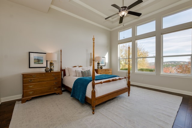 bedroom with ceiling fan, hardwood / wood-style flooring, a tray ceiling, and ornamental molding