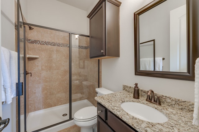 bathroom with toilet, a shower with door, and vanity